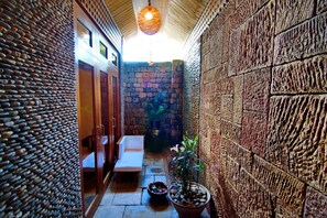 Stroll through this charming corridor, lined with a textured stone pattern and a wooden ceiling design.