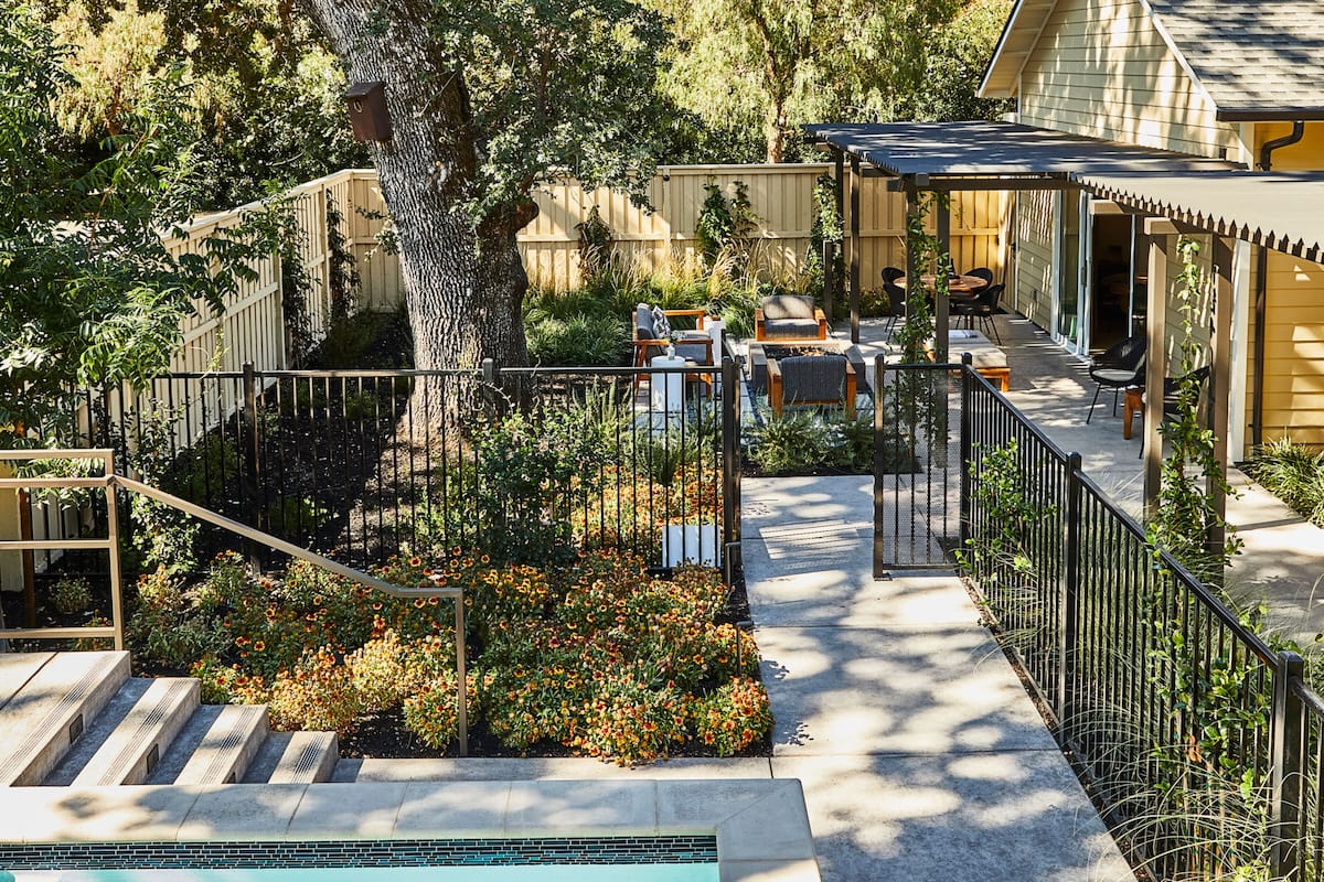 A pool area with a patio, outdoor seating, and a covered patio area.