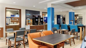 A modern cafe with seating areas, a coffee station, and a counter. - Holiday Inn Express Hotel & Suites Eugene Downtown-University by IHG (Eugene)