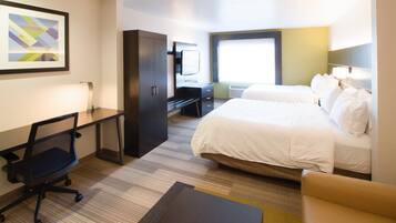 Una habitación de hotel con cama, escritorio, silla y televisor.