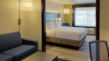 Una habitación de hotel con cama, sofá, escritorio y una silla.