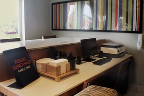 Un escritorio moderno de oficina con una computadora, teclado y un letrero que dice '¿Olvidaste algo? ¡Tómatelo aquí!'