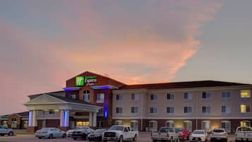 A Holiday Inn Express & Suites hotel with a parking lot full of cars.