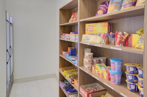 Un pasillo de supermercado con estantes llenos de diversas botanas y productos envasados.