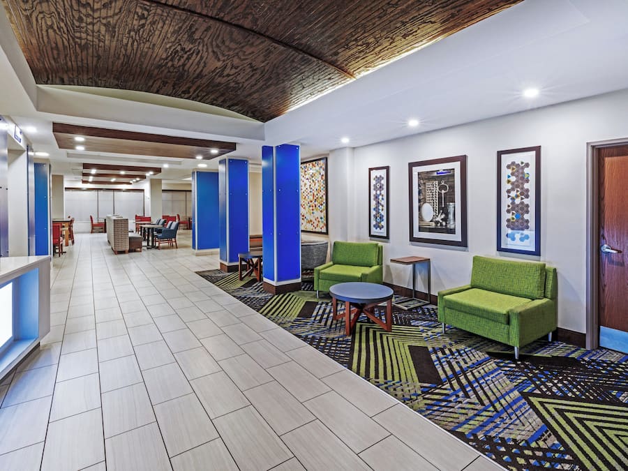 A hotel lobby with a reception desk, seating area, and a patterned carpet.
