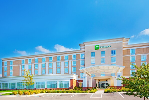 A Holiday Inn hotel with a modern facade, large windows, and a covered entrance.