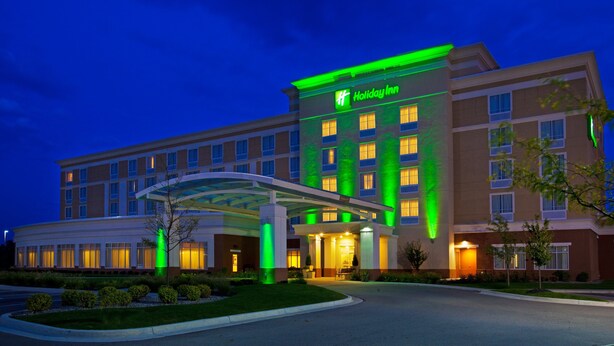 A Holiday Inn hotel with a modern design, featuring a large entrance canopy and a well-lit facade. - Holiday Inn Battle Creek by IHG (Battle Creek)