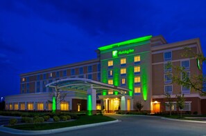 A Holiday Inn hotel with a modern design, featuring a large entrance canopy and a well-lit facade.