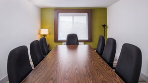 Una sala de conferències amb una taula de fusta i sis cadires.