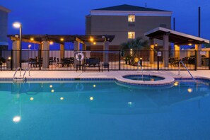 A swimming pool with a hot tub, surrounded by outdoor seating and a covered area with lights. - Holiday Inn Express Sierra Vista by IHG (Sierra Vista)