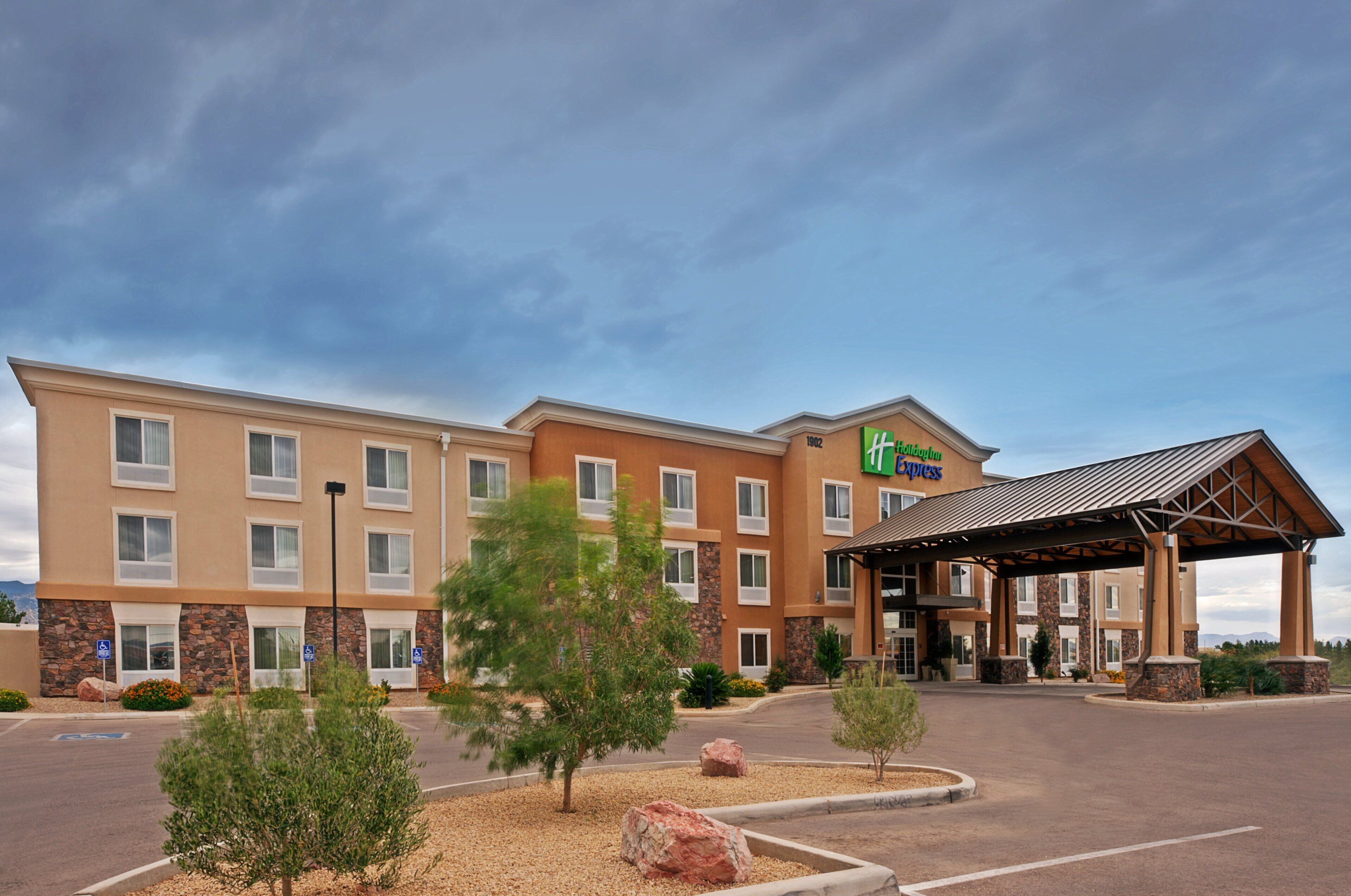 A Holiday Inn Express hotel with a covered entrance, multiple windows, and a parking lot.