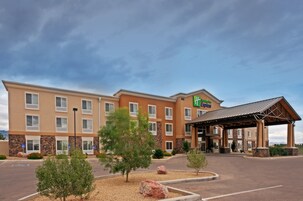 Un hotel Holiday Inn Express con un acceso cubierto, varias ventanas y un estacionamiento.