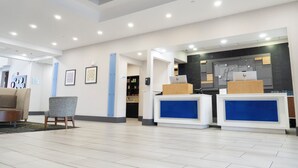 A hotel lobby with a reception desk, seating area, and framed artwork on the walls. - Holiday Inn Express & Suites Columbia-Fort Jackson by IHG (Columbia)