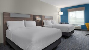 A hotel room with two beds, a desk, a chair, and a large window.