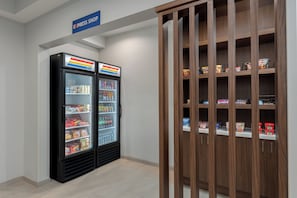 A clean, modern interior with two beverage dispensers and a wooden cabinet with snacks.