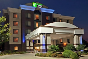 Un hôtel Holiday Inn Express doté d’une entrée abritée, de nombreuses fenêtres et d’une façade bien éclairée.