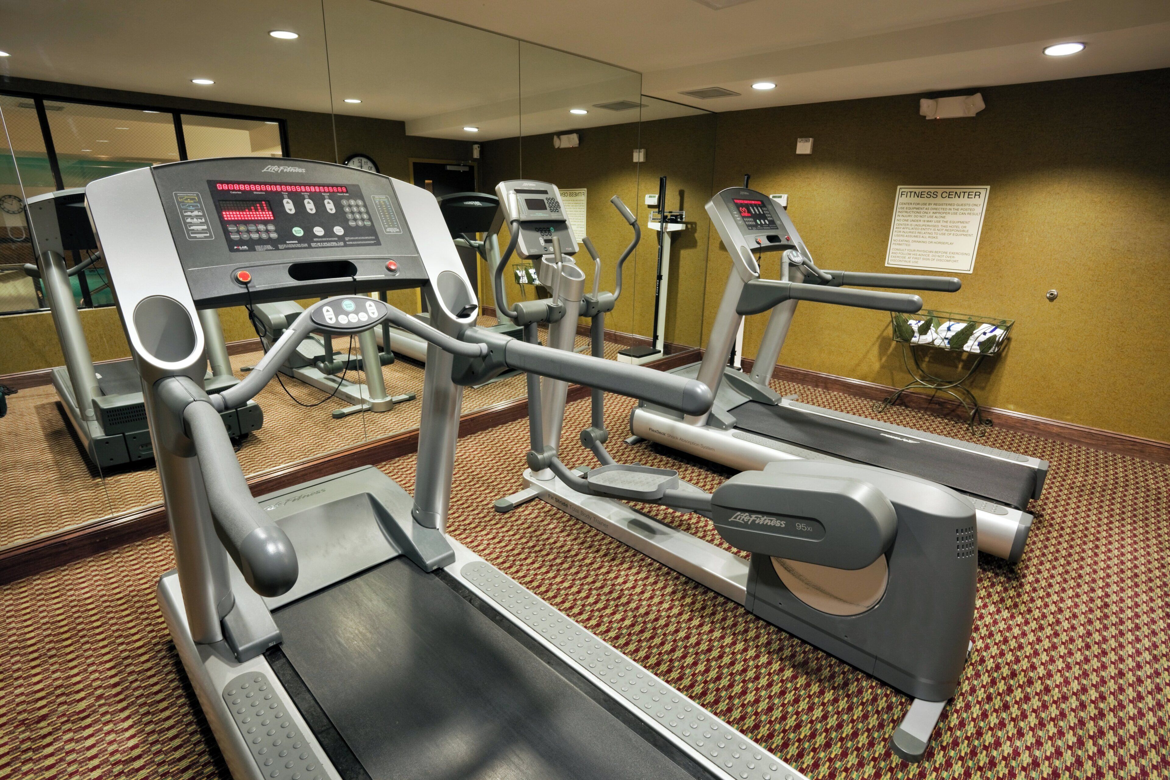 A fitness center with treadmills, ellipticals, and a stationary bike.