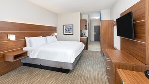 A modern hotel room with a large bed, wooden headboard, bedside tables, a flat-screen TV, and a small desk area. - Holiday Inn Express Hotel & Suites Birmingham - Inverness by IHG (Birmingham)