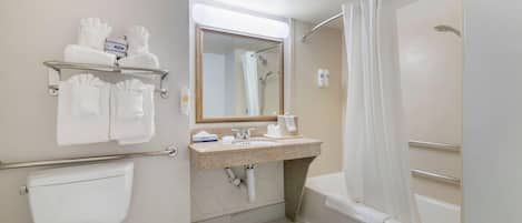 A bathroom with a toilet, sink, mirror, shower, and towel rack.