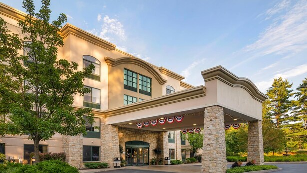 A hotel entrance with a stone facade, a covered entrance area, and a landscaped driveway. - Comfort Inn & Suites Lake George (Lake George)