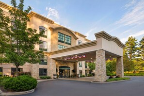 A hotel entrance with a stone facade, a covered entrance area, and a landscaped driveway. - Comfort Inn & Suites Lake George (Lake George)