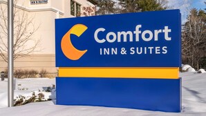 A Comfort Inn & Suites sign with a blue background and a yellow stripe. - Comfort Inn & Suites Lake George (Lake George)