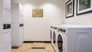 A laundry room with a sign detailing instructions, a washer, and a dryer.