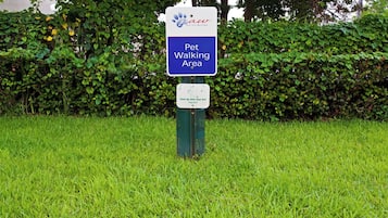 A sign indicating a pet walking area with a message to clean up after pets.