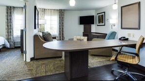 A hotel room with a large desk, a sofa, a TV, and a bed. - Candlewood Suites Ft. Lauderdale Airport/Cruise by IHG (Fort Lauderdale)