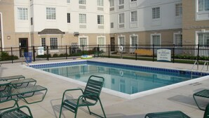 A swimming pool with green chairs and tables, surrounded by a black fence. - Staybridge Suites Cleveland Mayfield Heights Beachwood by IHG (Mayfield Heights)