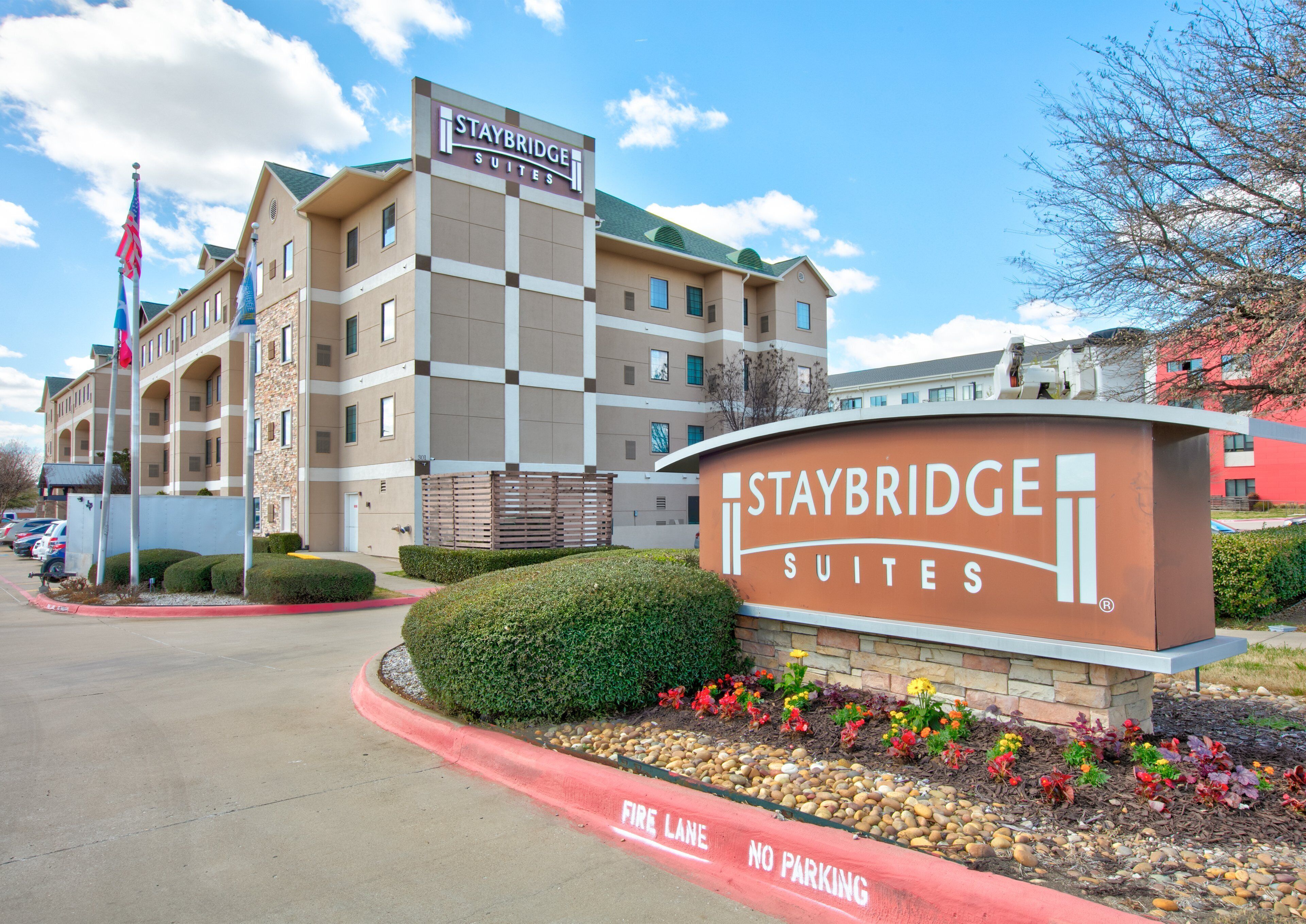 Staybridge Suites hotel with a sign, a parking lot, and a fire lane.