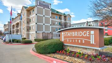 Staybridge Suites hotel with a sign, a parking lot, and a fire lane.