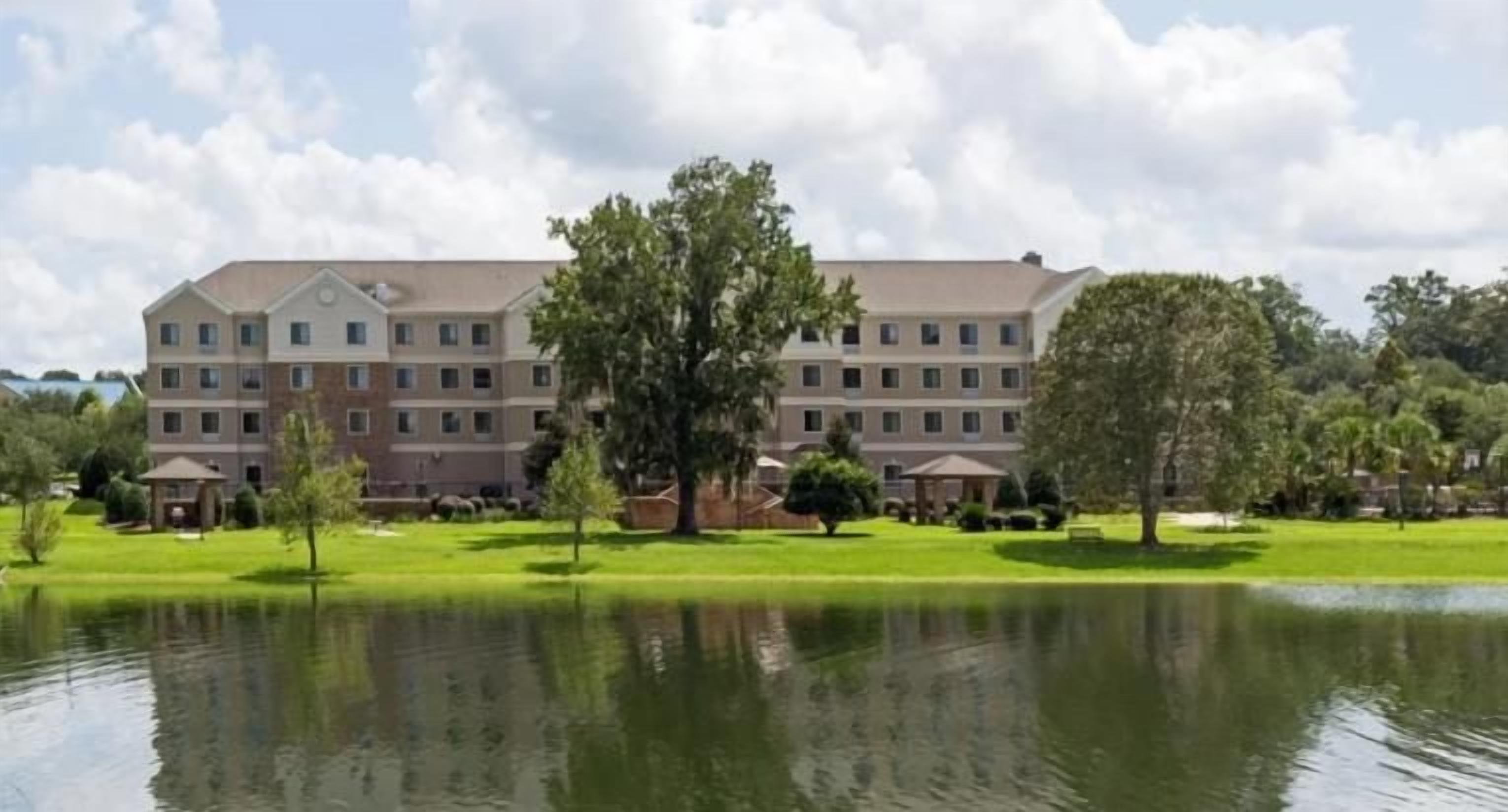 Un grand hôtel à étages, doté d’une cour intérieure avec un bassin et entouré de verdure.