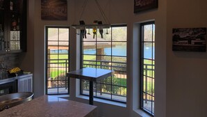 A modern kitchen with large windows, a hanging light fixture, and a view of a lake. - Staybridge Suites Tallahassee by IHG (Tallahassee)
