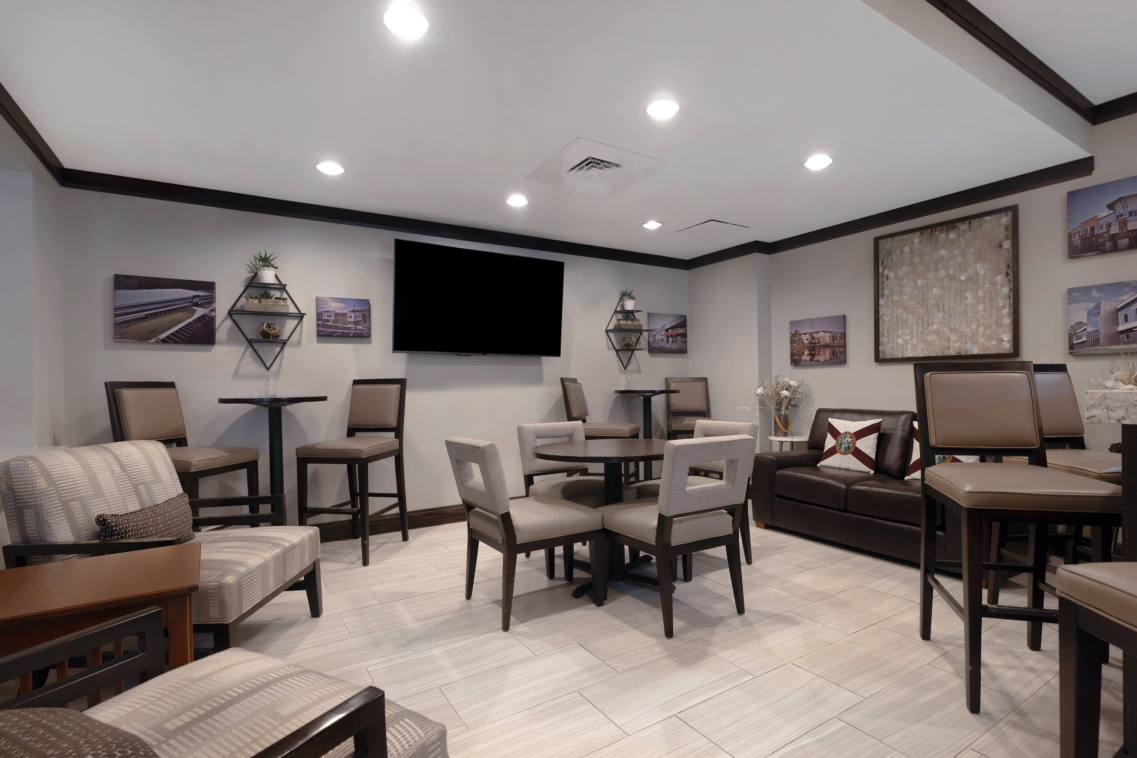 A modern living room with a flat-screen TV, comfortable seating, and a dining area.