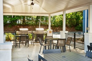 An outdoor patio with a grill, tables, and chairs. - Candlewood Suites I-26 at Northwoods Mall by IHG (North Charleston)