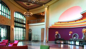 A lobby with a grand chandelier, comfortable seating, and a vibrant wall design. - Argosy Casino & Hotel (Riverside)