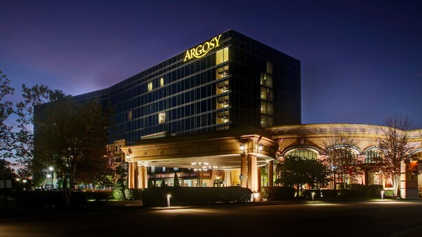 A modern hotel with a prominent 'ARGOSY' sign, featuring a glass facade and classical architectural elements like columns and arches. - Argosy Casino & Hotel (Riverside)