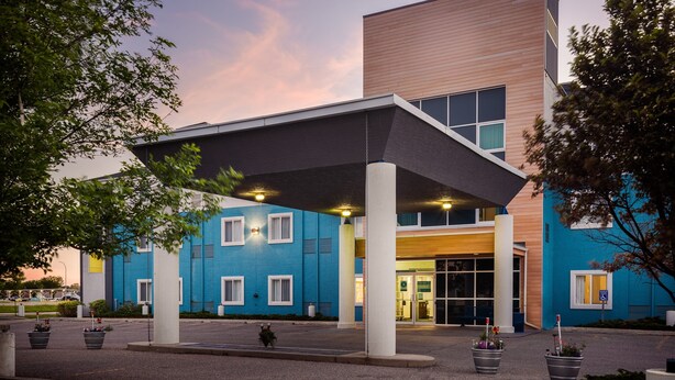 A modern building with a blue facade, large windows, and a covered entrance area. - Prairie Crest Medicine Hat (Medicine Hat)