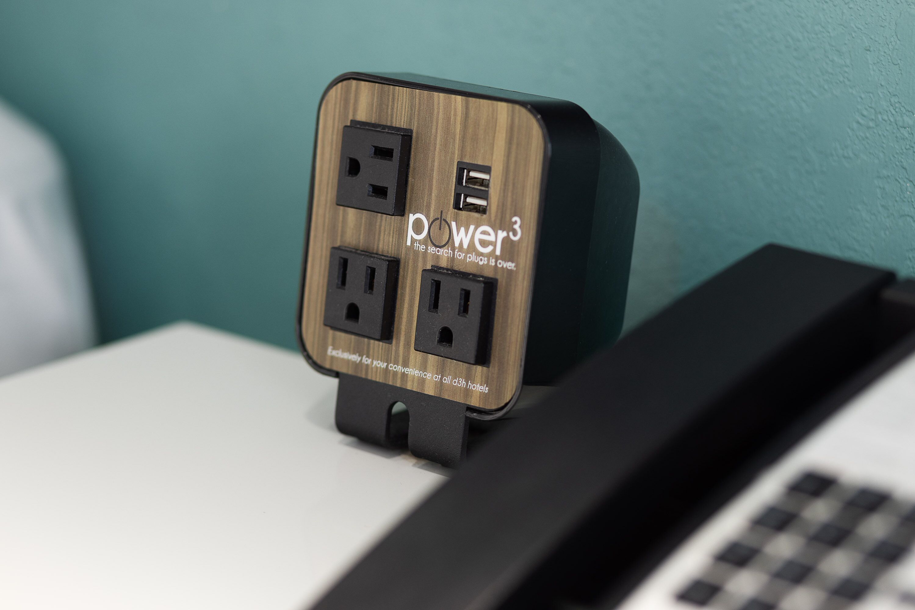 A power strip with a wooden finish and the text "power3" and "the search for plugs is over."