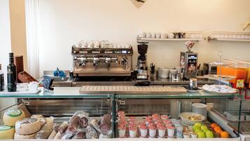 A breakfast buffet with various food items, a coffee machine, and a display of dairy products.