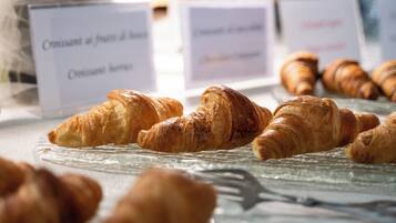 Een presentatie van croissants op een glazen bord met labels die verschillende soorten aanduiden.