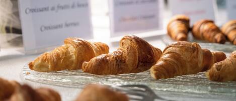 A display of croissants on a glass plate with labels indicating different types.