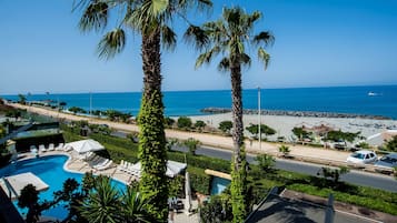 Een buitenzwembad, parasols voor strand/zwembad