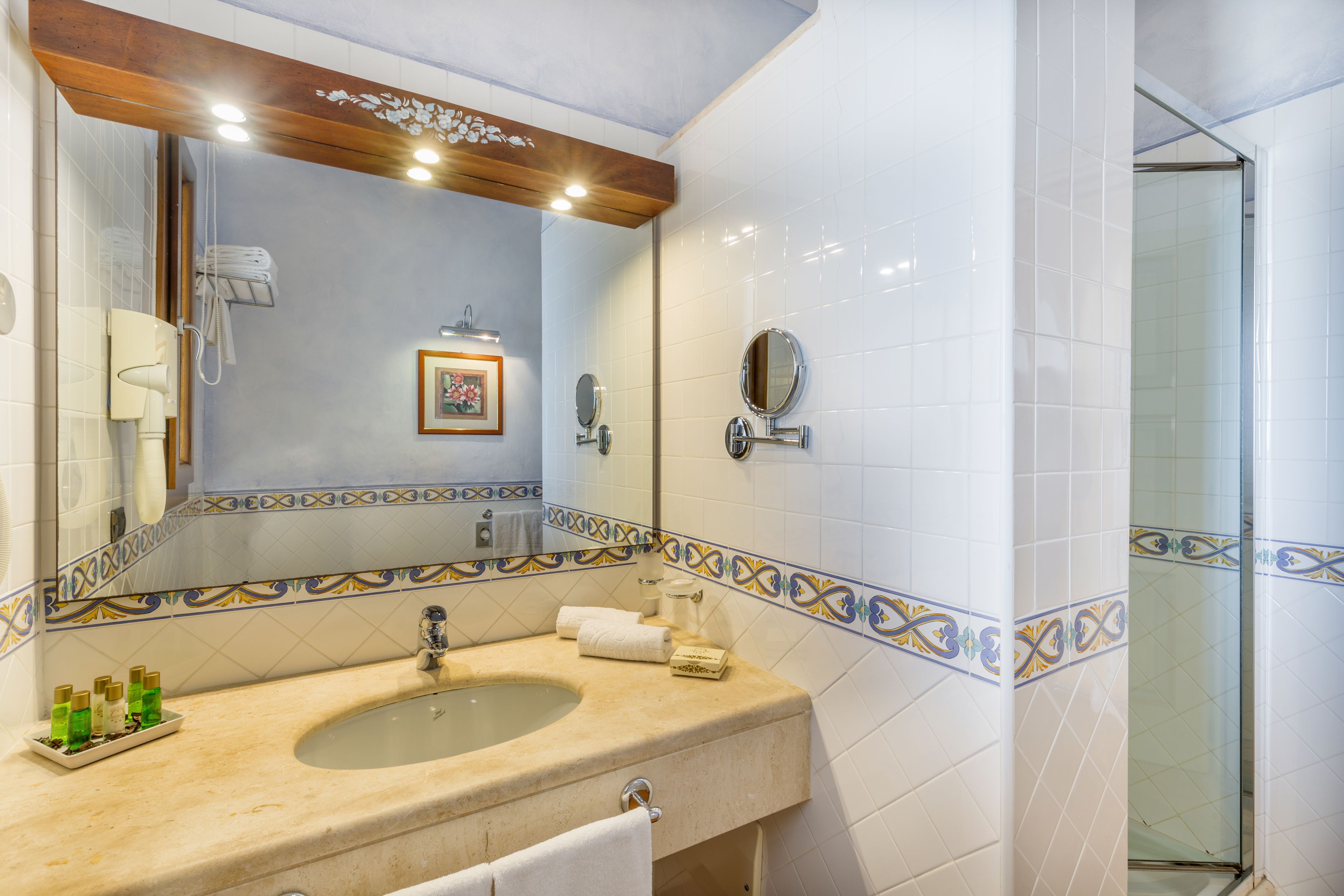 A bathroom with a sink, mirror, and shower.