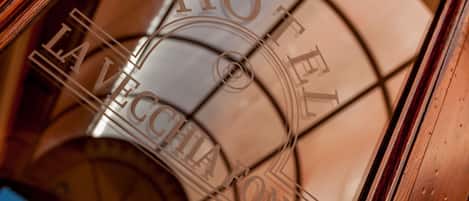 A close-up of a circular, reflective surface with the words "HOTEL" and "LA VECCHIA LONYA" visible.