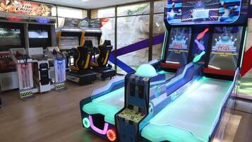 Un salón recreativo con diversas máquinas, incluyendo juegos de bolos 'Lane Master'.