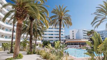 Un resort con piscina, palmeras y edificios modernos.