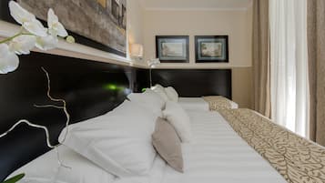 Una habitación de hotel con una cama grande, un cabecero, una obra de arte colgada en la pared y dos cuadros enmarcados.