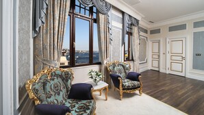 Una habitación amplia con muebles decorados, ventanas grandes y vistas a la ciudad.